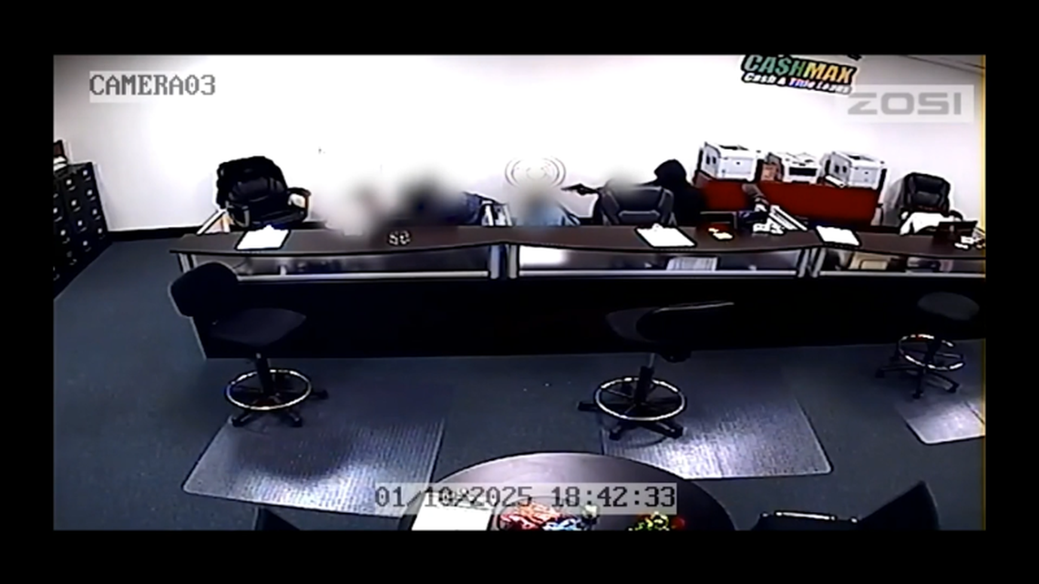 One of the suspects in the Jan. 10, 2025, robbery of a CashMax store in Arlington points a gun at employees in this image from video released by police. The robbers bound the employees’ arms and legs with tape, investigators said. Officers exchanged gunfire with one of the suspects, but no one was injured, according to police.