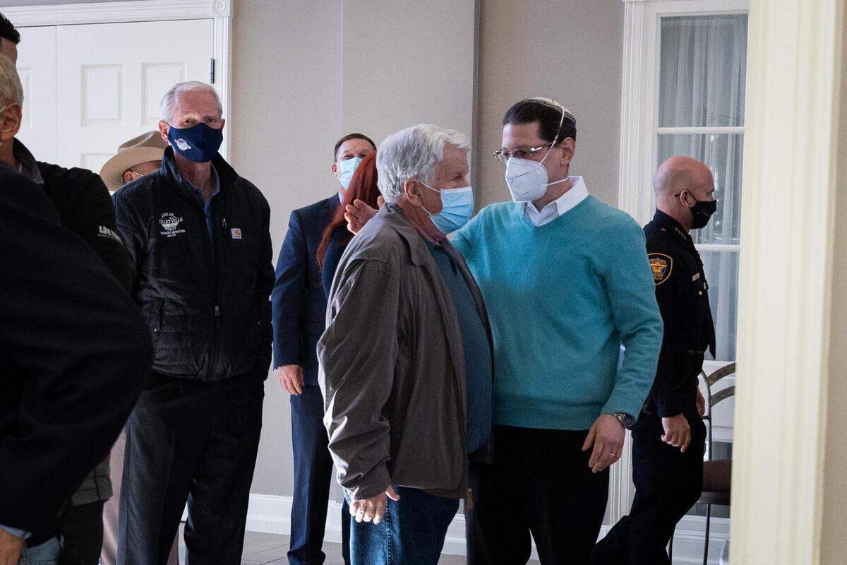 Rabbi Charlie Cytron-Walker, Congregation Beth Israel, right, talks to another man talks before a press conference Friday, Jan. 21, 2022, in Colleyville.