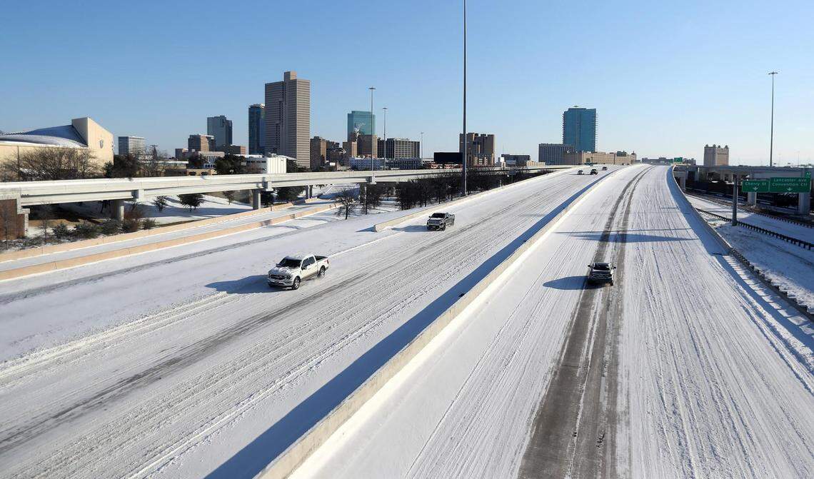 Vehicles drive on a snowy Interstate 30 on Feb. 15, 2021, in Fort Worth. North Texas experienced record breaking low temperatures and the entire state of Texas was under a winter warning advisory.