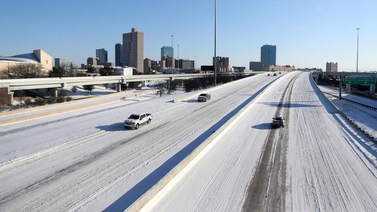 Vehicles drive on a snowy Interstate 30 on Feb. 15, 2021, in Fort Worth.