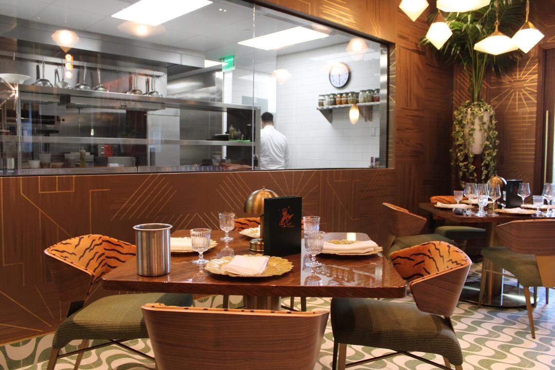 A dining room in The Mont gives sight into the clean kitchen for dinner and a show.