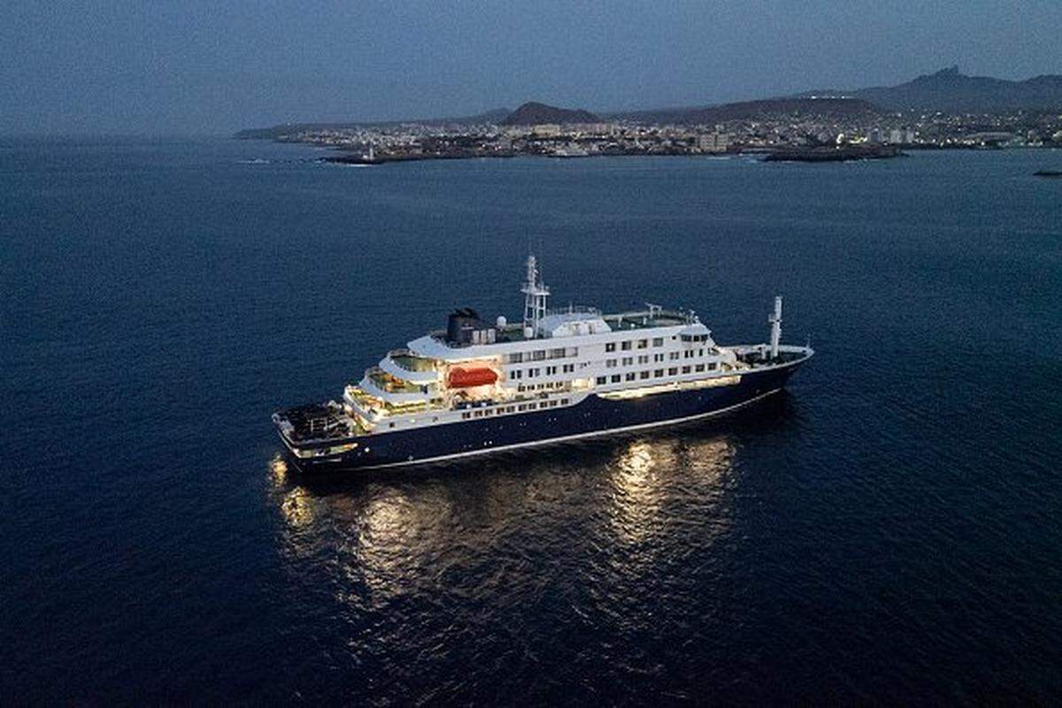 A general view of the cruise ship MV Hondius, while stationary off the port of Praia, the capital of Cape Verde, on May 6, 2026. Two seriously ill crew members on a cruise ship stricken by a deadly hantavirus outbreak will be evacuated via Cape Verde to the Netherlands, allowing the vessel to sail on to Spain's Canary Islands, the ship operator said on May 5, 2026. The MV Hondius has been at the centre of an international health scare since Saturday, when WHO was informed that the rare disease -- usually spread from infected rodents typically through urine, droppings and saliva -- was suspected of being behind the deaths of three of its passengers. As others fell ill, passengers and crew have been in isolation after Cape Verde authorities barred the ship from docking, and as health authorities scrambled to find a port that would take the Hondius. (Photo by AFP via Getty Images)