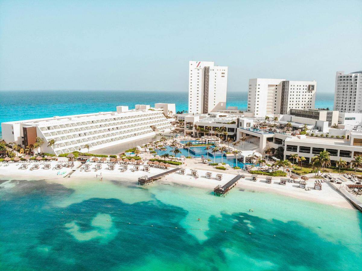 Cancun’s crystal clear water appears turquoise against the white sand and reefs.