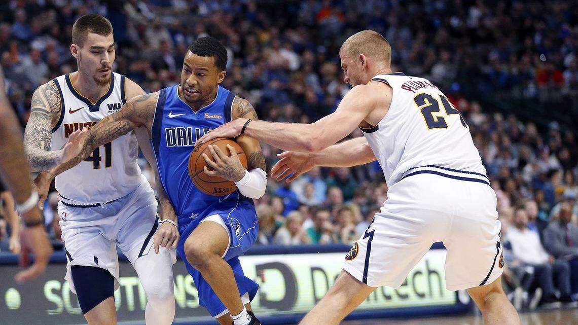 The Dallas Mavericks’ Trey Burke is fouled as he drives between the Denver Nuggets’ Juan Hernangomez (41) and Mason Plumlee (24) in the first half at the American Airlines Center in Dallas on Friday, Feb. 22, 2019. (Tom Fox/Dallas Morning News/TNS)