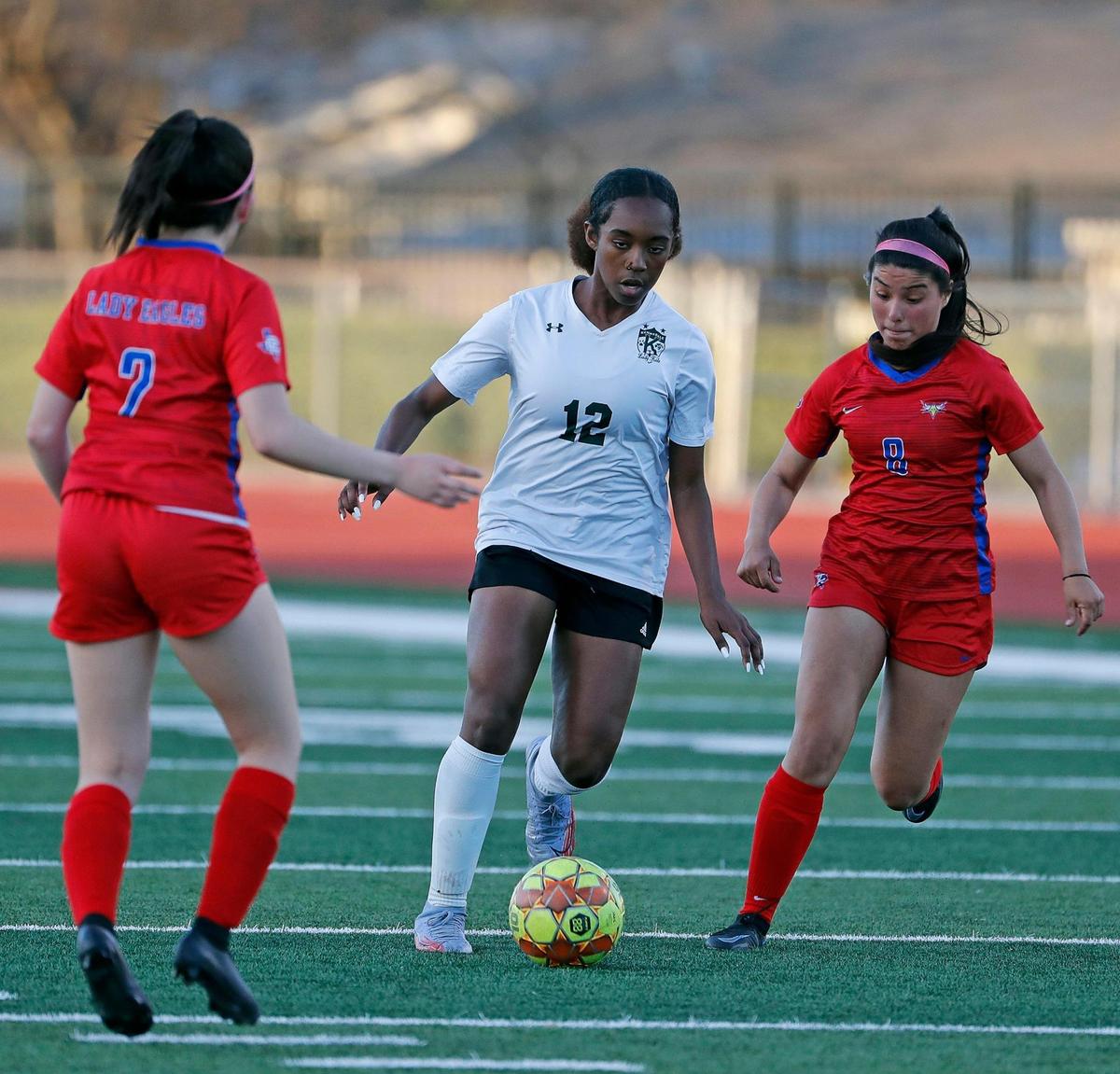 Kennedale’s Lauren McIntyre (12) splits the defense of Carter Riverside’s Mairely Galvan (2) and Jairy Alvarez (8) during a 4A Region 1 bi-district girls soccer playoff game at Elk Stadium in Burleson, Texas, Friday, Mar. 25, 2022. Kennedale moves on after defeating Carter Riverside 5-1. (Special to the Star-Telegram Bob Booth)