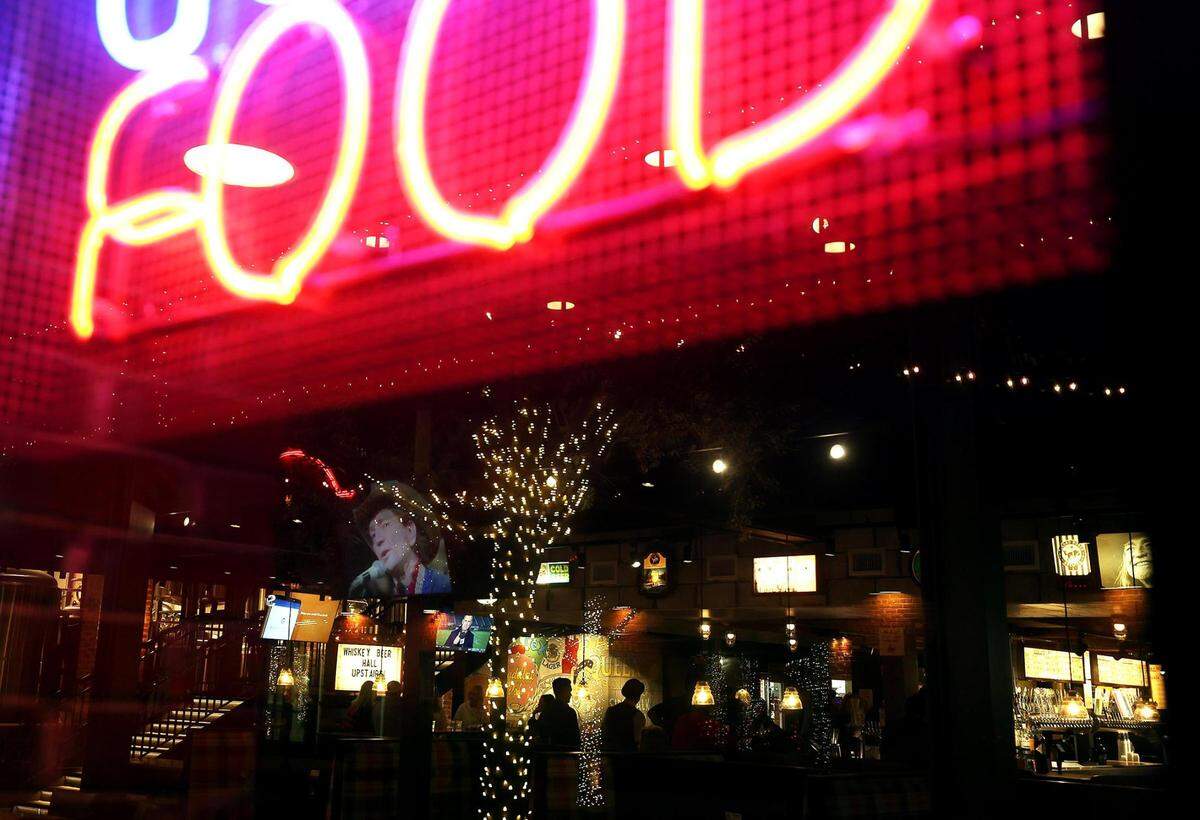 Patrons can be seen silhouetted inside Second Rodeo Brewery, located Mule Alley, which features a brewery and bar garden, food and live music.