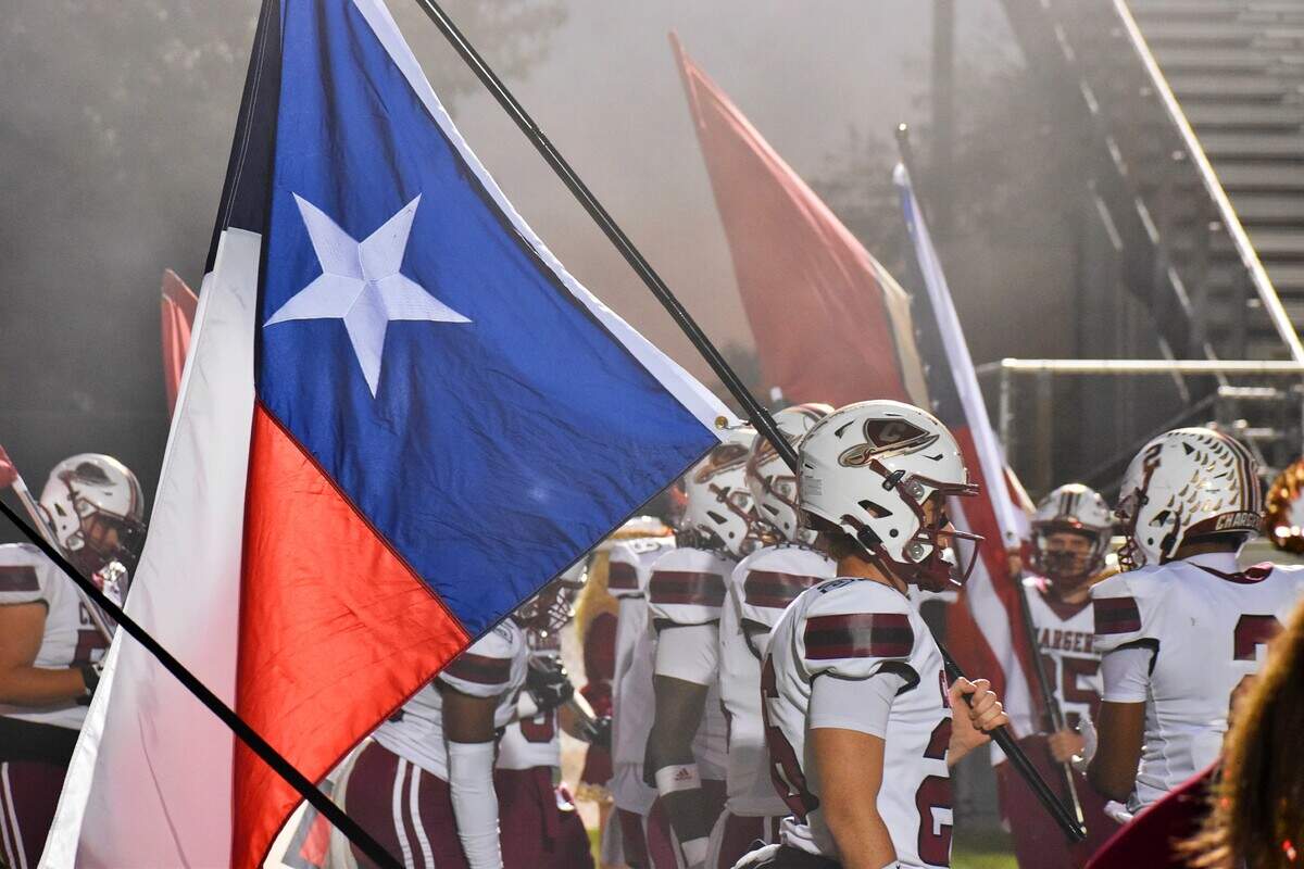 Keller Central’s Luke Hamilton waits to run out onto the field, while holding the Texas flag, before the game on Friday against Southlake Carroll at Dragon Stadium on Friday, October 31, 2025.