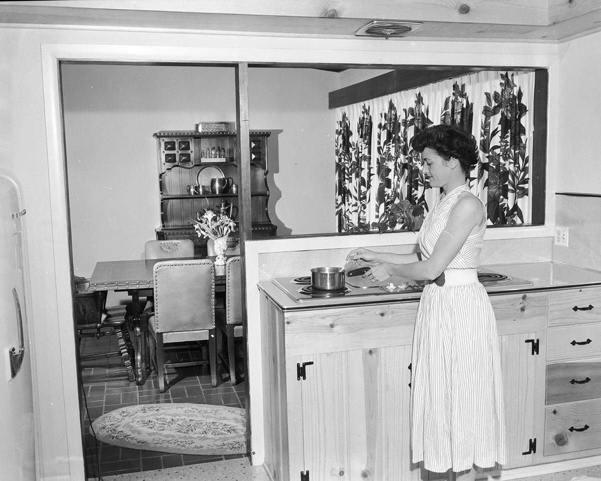 April 6, 1954: Mrs. J. D. Jelley, 5408 Calloway Road, can cook on her built-in stove in the kitchen and keep an eye on what’s going on the dining room at the same time, as shown here. On the lower shelf of the Viking oak hutch is a silver service brought by Maj. Jelley from Berlin when he was participating in the airlift in 1948.