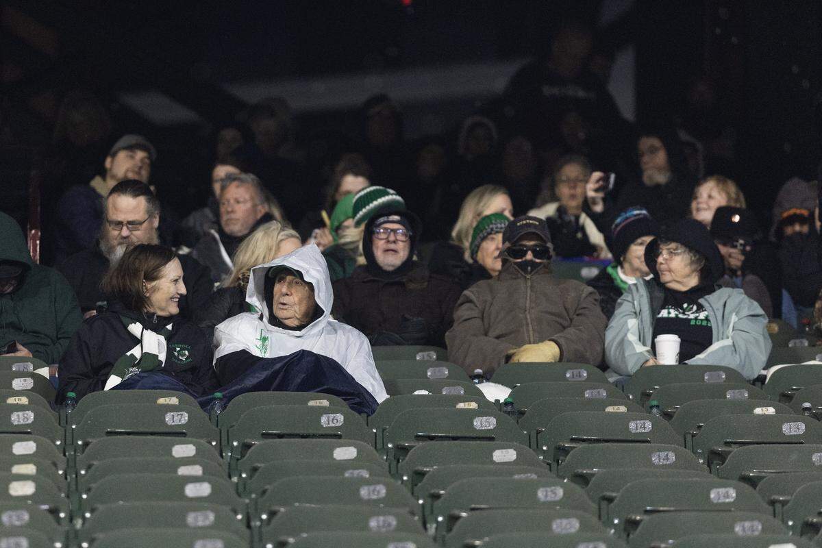 Spectators bundle up during a weather delay in the UIL Division II Regional playoff game at Choctaw Stadium in Arlington on Friday, Nov. 28, 2025.