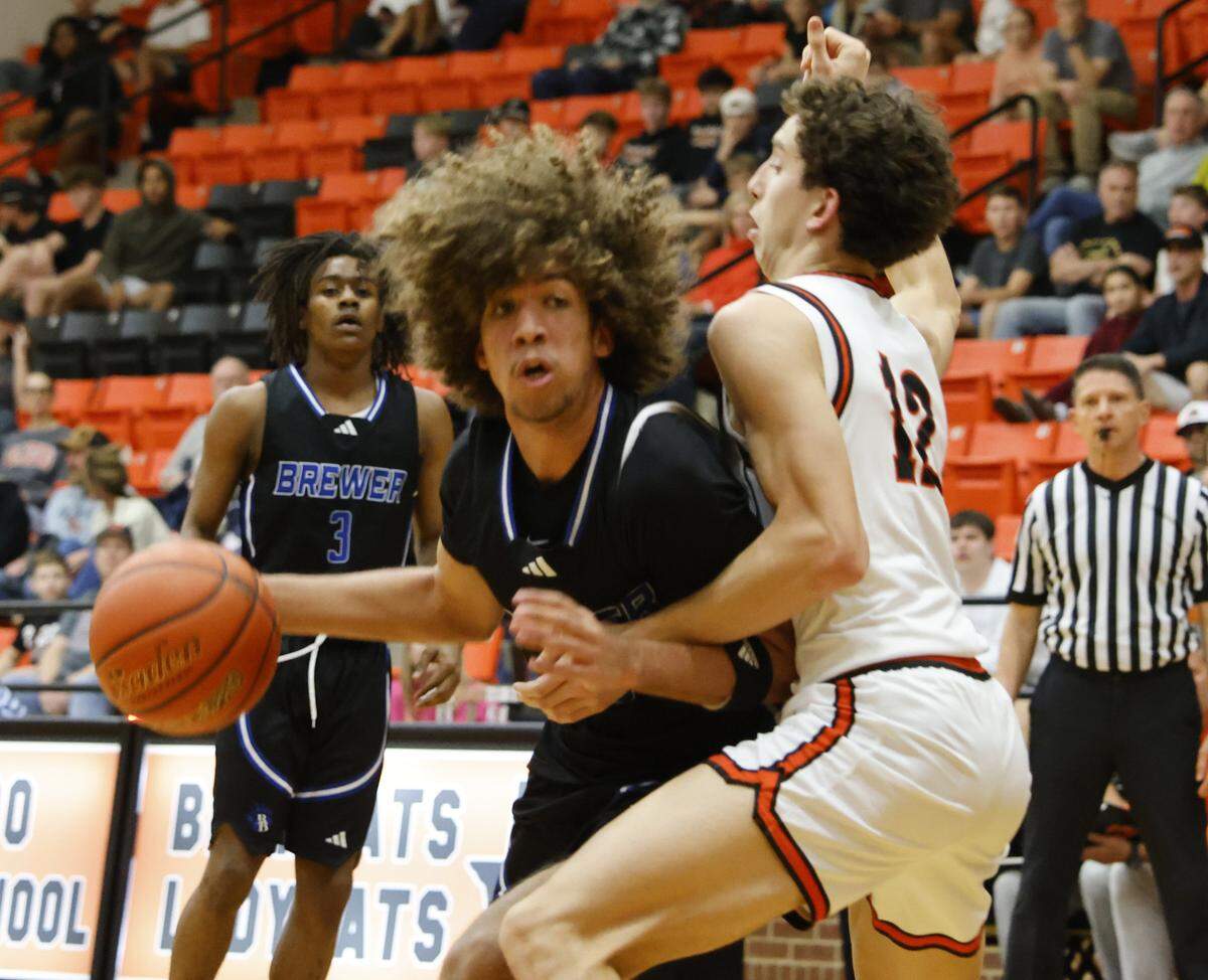 Brewer center Jayden Johnson (30) crosses Aledo forward Grayson Isbell (12) during the first half of a UIL boys basketball game at Aledo High School in Aledo, Texas, Friday Feb. 13, 2026.