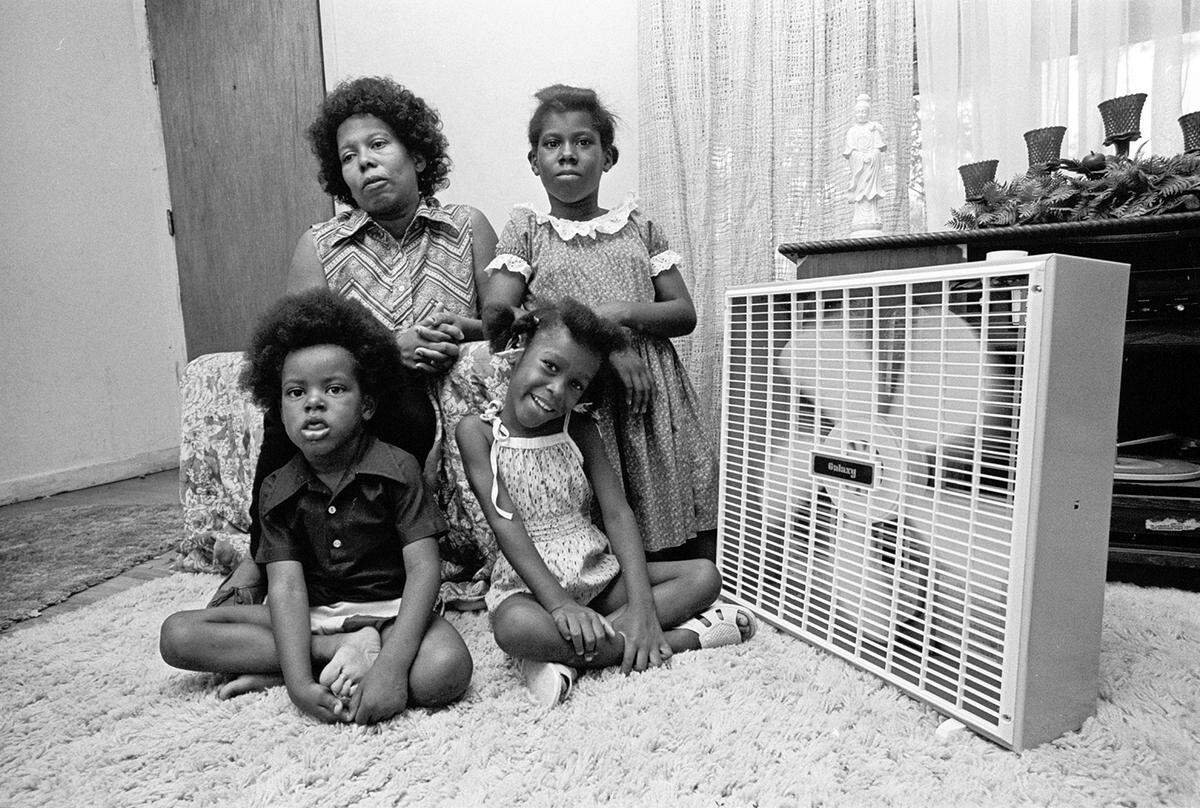 July 29, 1980: Vera Darnell, daughter Fatima, 12, and grandchildren Shannon, 3, and Alisha, 4, in their living room with a fan, getting relief from the heat. The window fan was given to the family by a volunteer from the Tarrant County United Way.