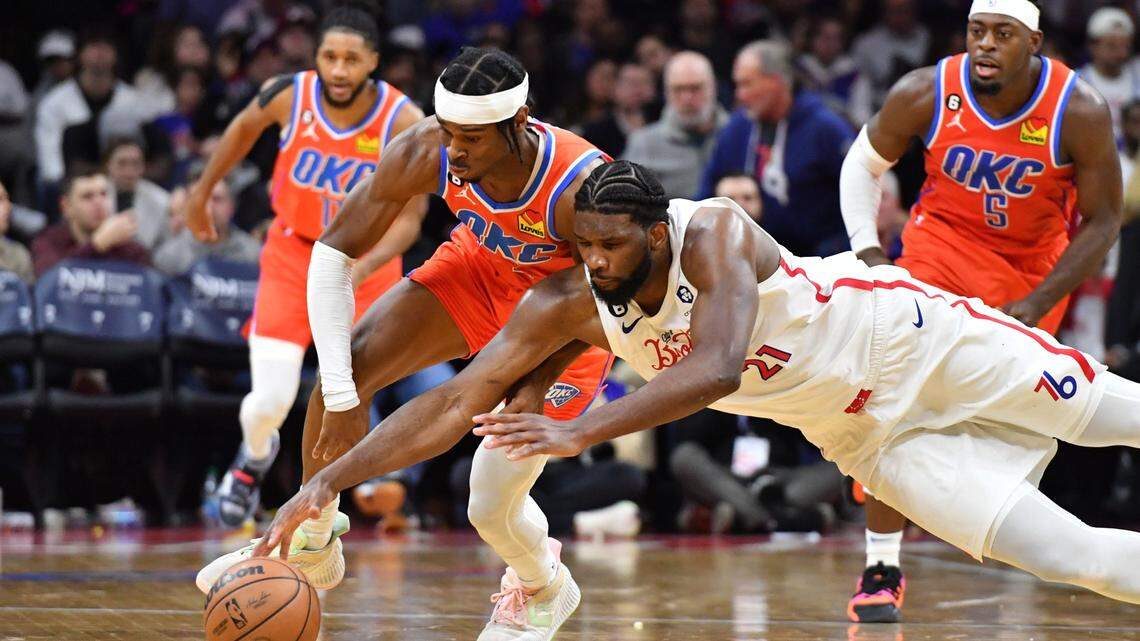 Jan 12, 2023; Philadelphia, Pennsylvania, USA; Oklahoma City Thunder guard Shai Gilgeous-Alexander (2) dives for loose ball with Philadelphia 76ers center Joel Embiid (21) during the fourth quarter at Wells Fargo Center. Mandatory Credit: Eric Hartline-USA TODAY Sports