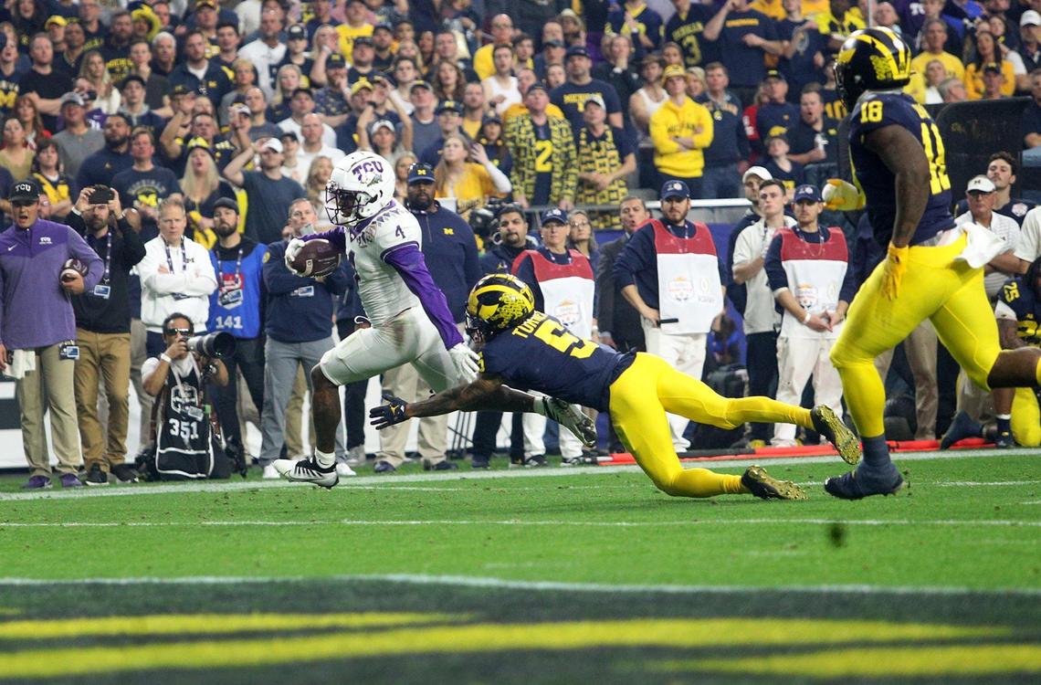 TCU wide receiver Taye Barber slips past Michigan defensive back D.J. Turner to score a touchdown during the first half of the Vrbo Fiesta Bowl at State Farm Stadium in Glendale, Ariz., on Saturday, December 31, 2022.