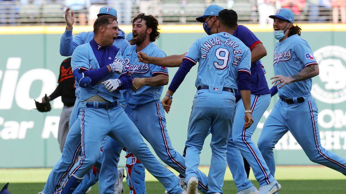 Nate Lowe is mobbed by Texas Rangers teammates after hitting a walk-off single that scored Eli White to beat the Baltimore Orioles 1-0 in the 10th inning Sunday afternoon at Globe Life Field in Arlington.
