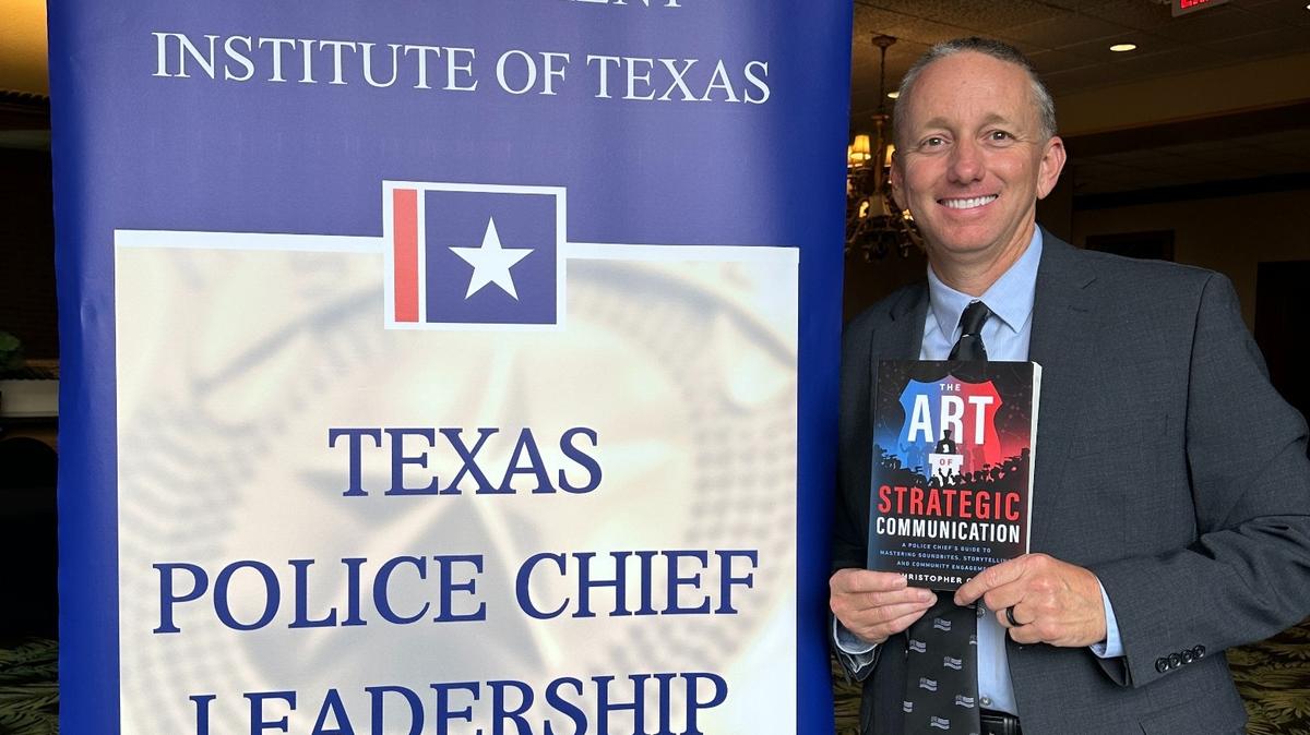 White Settlement Police Chief Christopher Cook poses with a copy of his book “The Art of Strategic Communication,” which was published on Wednesday, May 8, 2024.