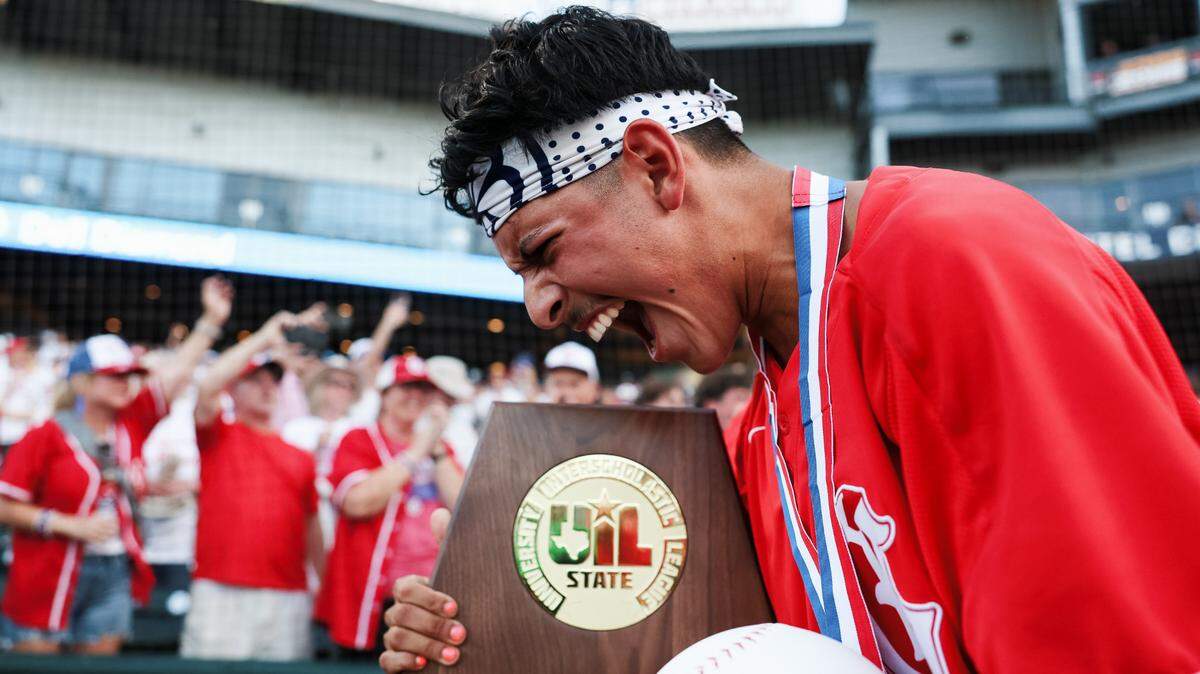Grapevine catcher Gianni Corral celebrates while holding the championship trophy after the Mustangs defeated Kingwood Park 9-5 in the Class 5A Division II state championship game on Friday, June 6, 2025 at Dell Diamond in Round Rock, Texas.