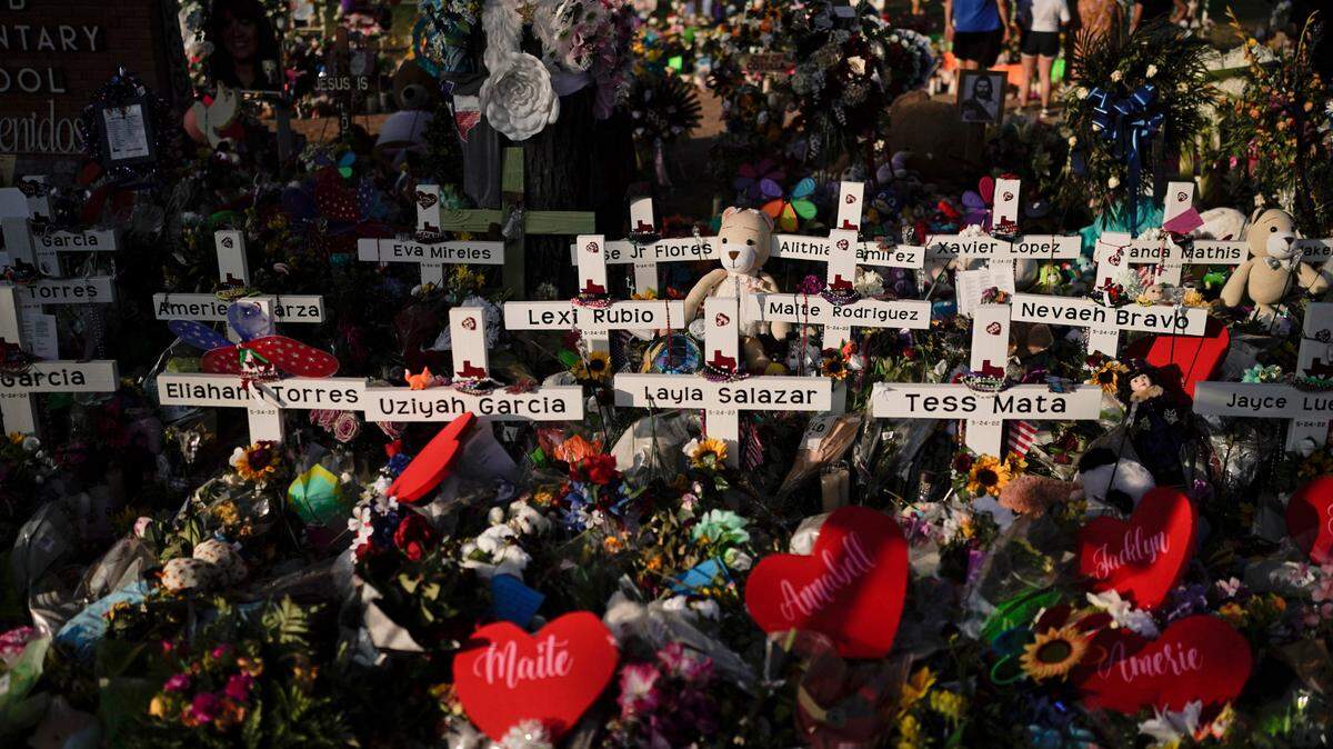 Flowers are piled around crosses with the names of the victims killed in last week’s school shooting as people visit a memorial at Robb Elementary School to pay their respects, Tuesday, May 31, 2022, in Uvalde, Texas. (AP Photo/Jae C. Hong)