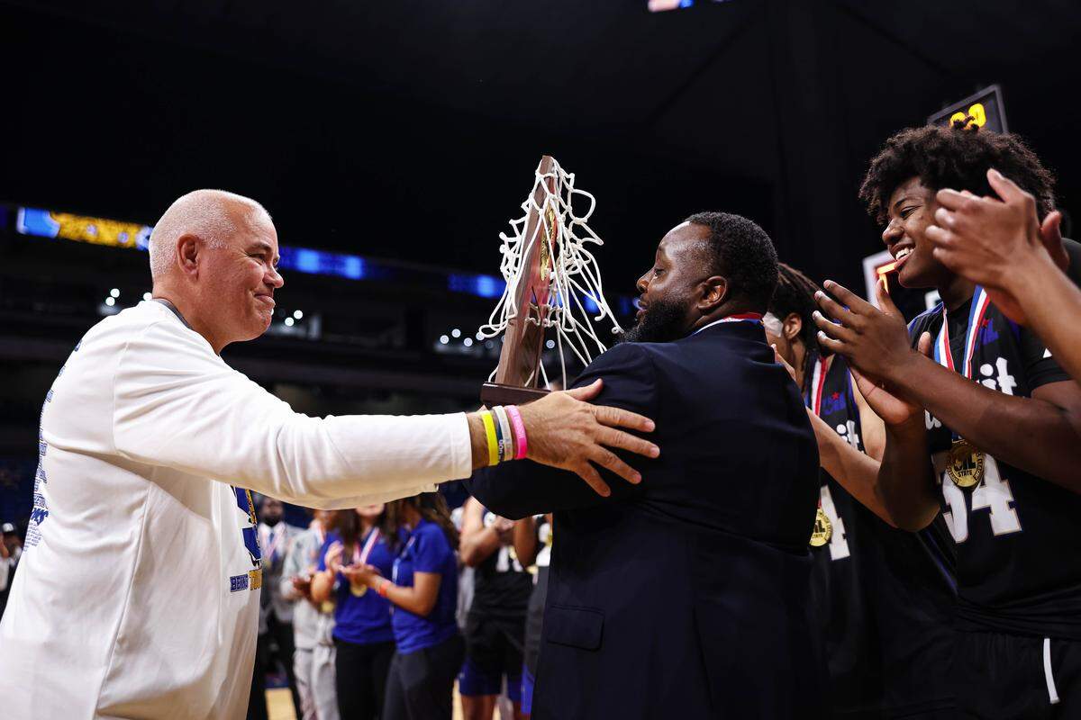 Mansfield Summit head coach Emund Prichett receives the championship trophy after the Class 5A Division II state title game against Beaumont United on Saturday at the Alamodome in San Antonio.
