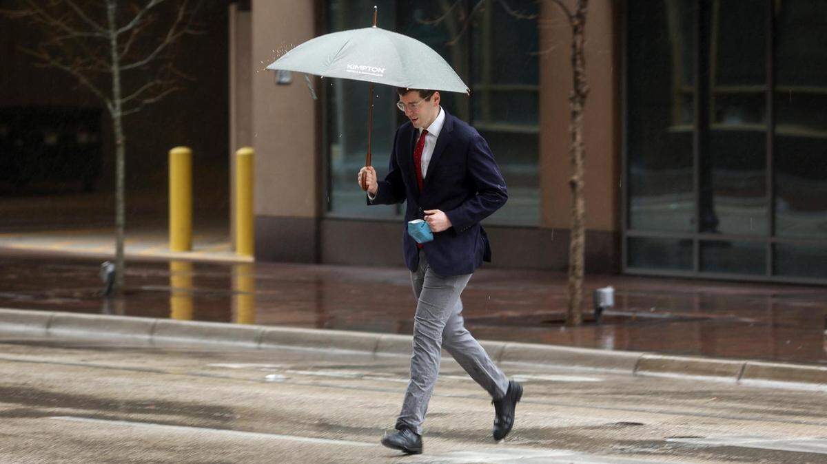 A pedestrian crosses Throckmorton Street at West 7th Street as rain falls Monday afternoon, March 21, 2022, in downtown Fort Worth.