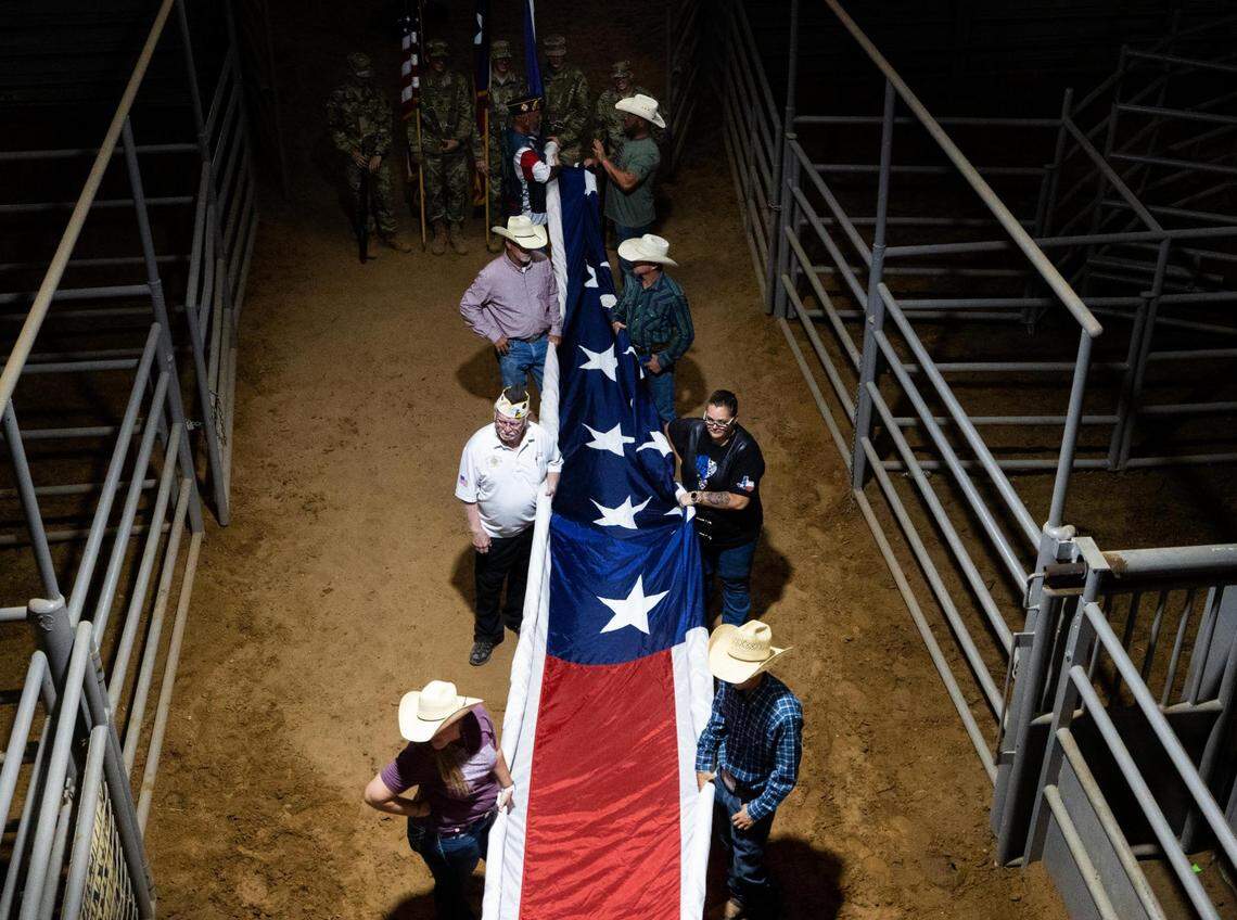 People hold a giant American flag before the first performance of the Cowboy Capital of the World PRCA Rodeo on Friday, Sept. 23, 2022, in Stephenville.