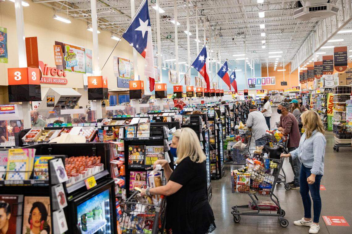 Texas flags are posted over the cash registers as customers wait to check out at the H-E-B in Hudson Oaks on Friday, March 26, 2021. 