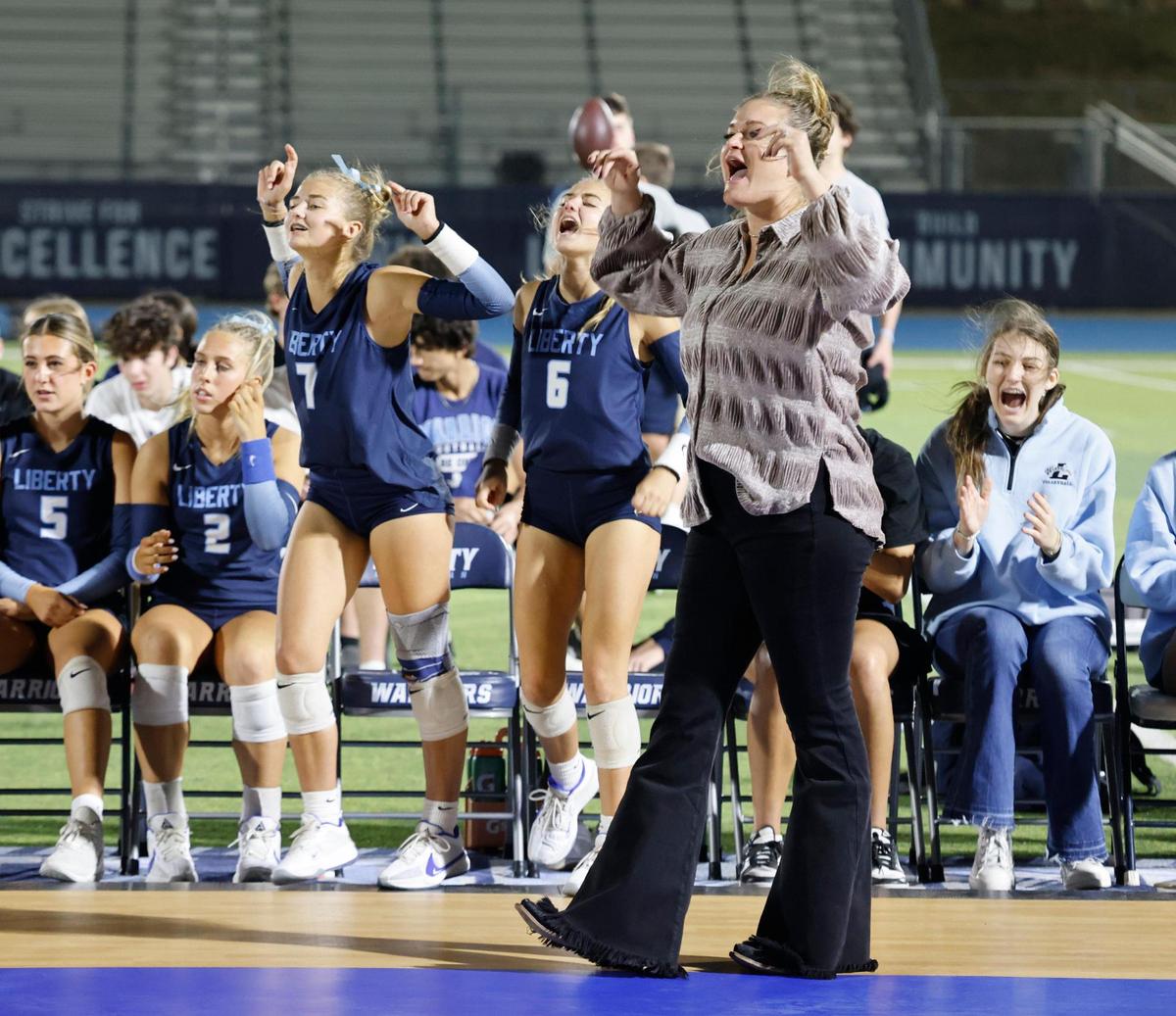 Liberty Christian head coach Megan DeGroot celebrates a point with her team during the Showdown at Sundown outdoor exhibition volleyball game at Liberty Christian High School in Argyle, Texas, Tuesday, Oct. 29, 2024.