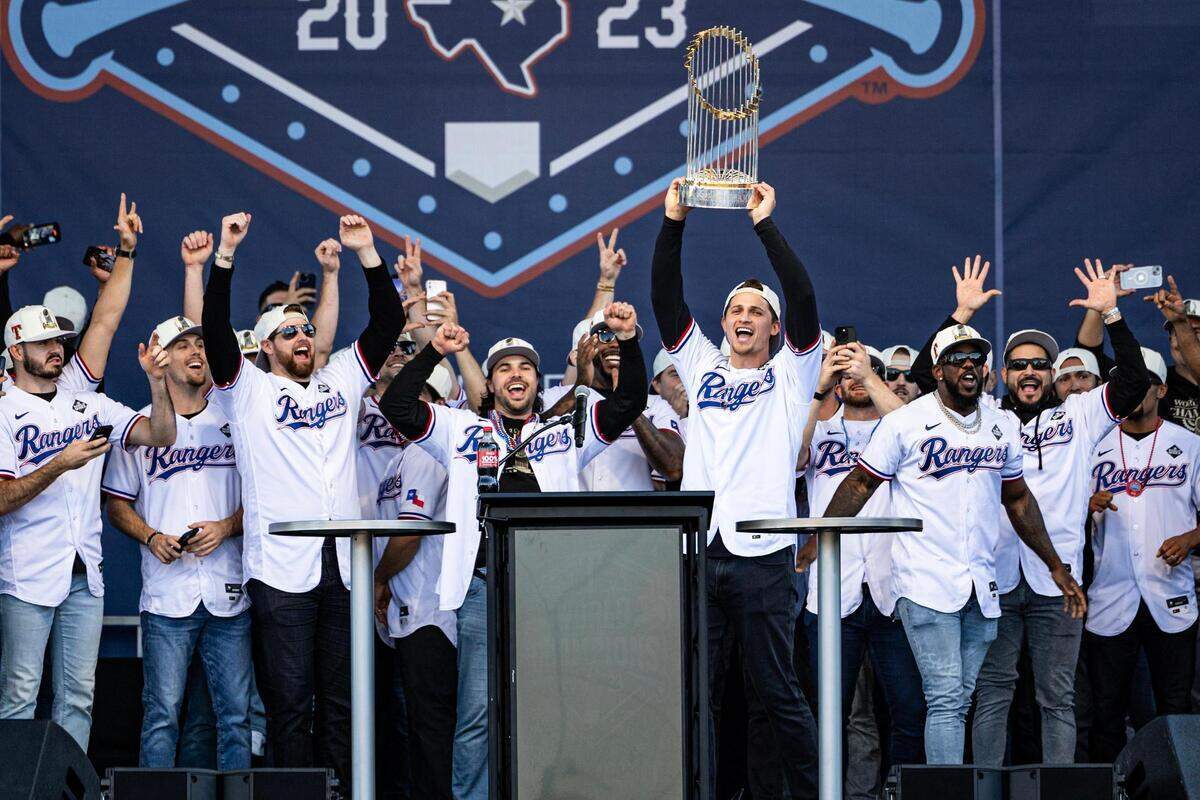 Rangers shortstop Corey Seager holds up the World Series Trophy during their Championship Ceremony at the Texas Live! Plaza in Arlington on Friday, Nov. 3, 2023.