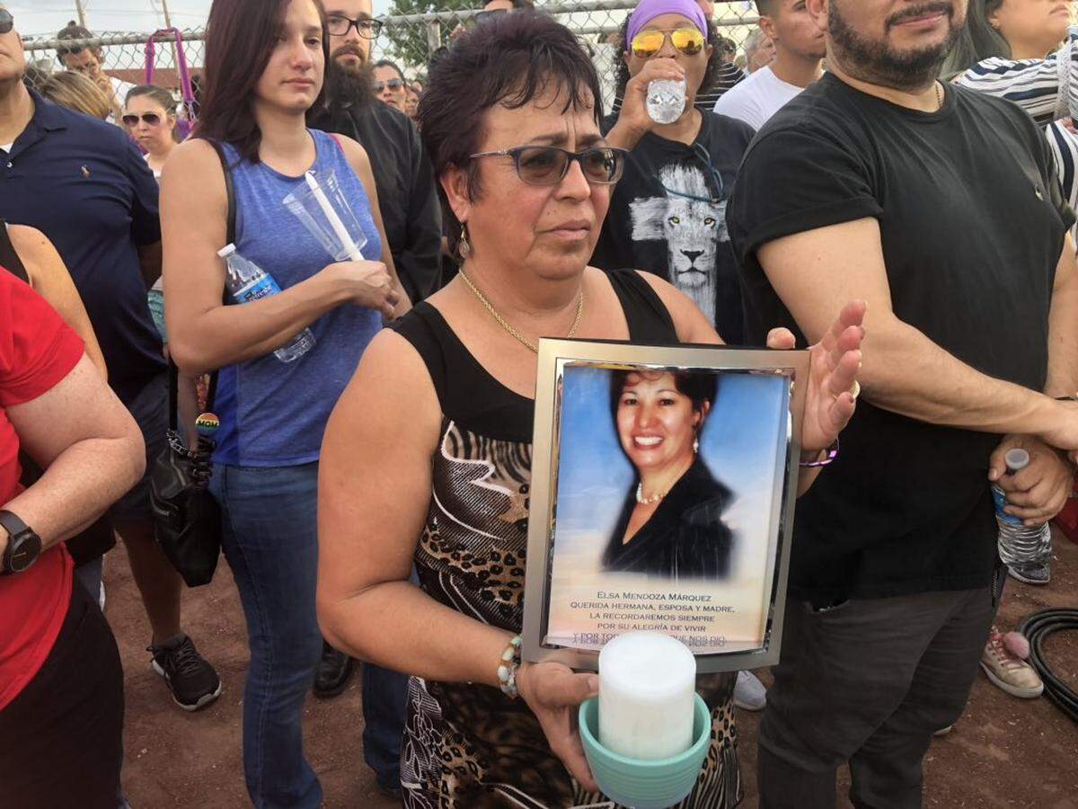 Lupe Lopez is holding a photo of her friend Elsa Mendoza Marquez, who died Saturday. Her friend was a teacher in Juarez and went into Walmart to buy school supplies, she said. “Her husband and son waited in the car. She never came out.”