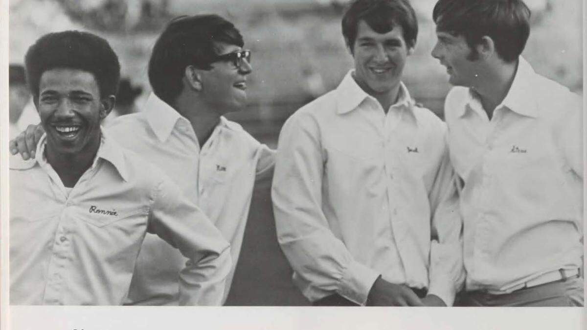 Ron Hurdle, left, laughing with friends, in this file photo. Hurdle was the first Black cheerleader at TCU.