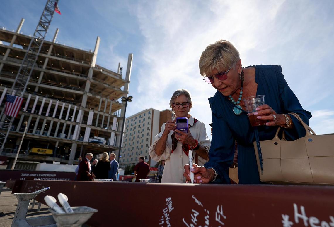 Former Fort Worth Mayor Betsy Price signs her name to the final beam during a topping out ceremony for the Texas A&M-Fort Worth Law and Education Building currently under construction on Monday, Nov. 11, 2024.