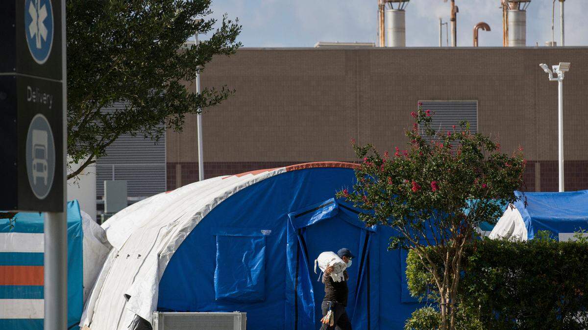 A construction crew works Monday to set up tents that hospital officials plan to use with an overflow of COVID-19 patients outside of Lyndon B. Johnson Hospital in Houston.