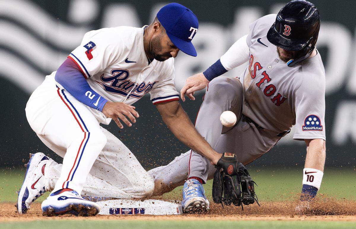 Rangers second baseman Marcus Semien (2) fails to tag out Red Sox short stop Trevor Story (10) on a steal attempt in the ninth inning of the MLB Opening Day game between the Rangers and Red Sox at Globe Life Field in Arlington on Thursday, March 27, 2025.