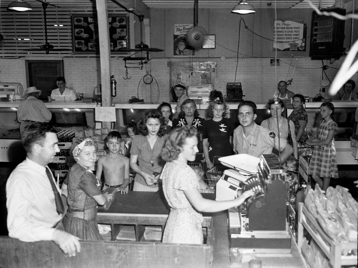 Manager J. H. Patton looks on as a clerk rings up an order at the Hill and Mack Grocery store in the Liberator Village shopping center in September 1945. 