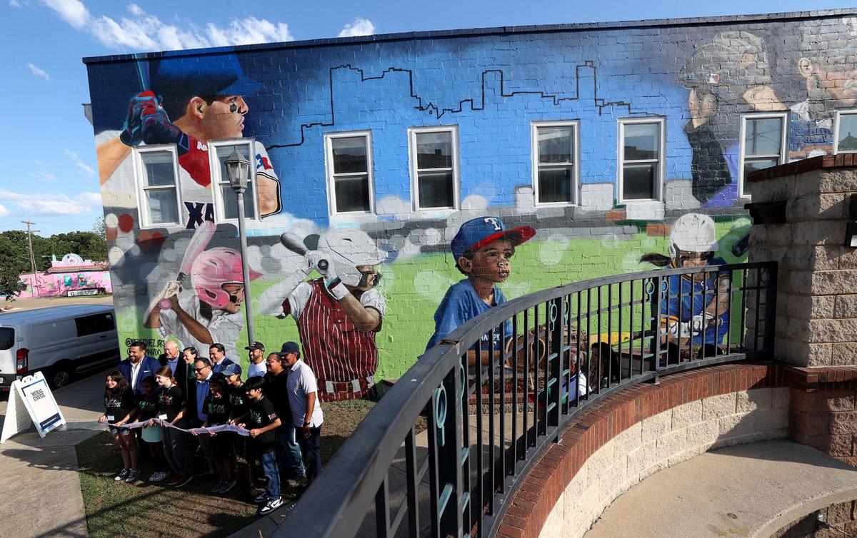 Children of the Artes de La Rosa Cultural Center, MLB officials and city representatives take photos in front of a mural celebrating MLB All-Star Week and Latino softball and baseball players on Wednesday, July 10, 2024, in Fort Worth.