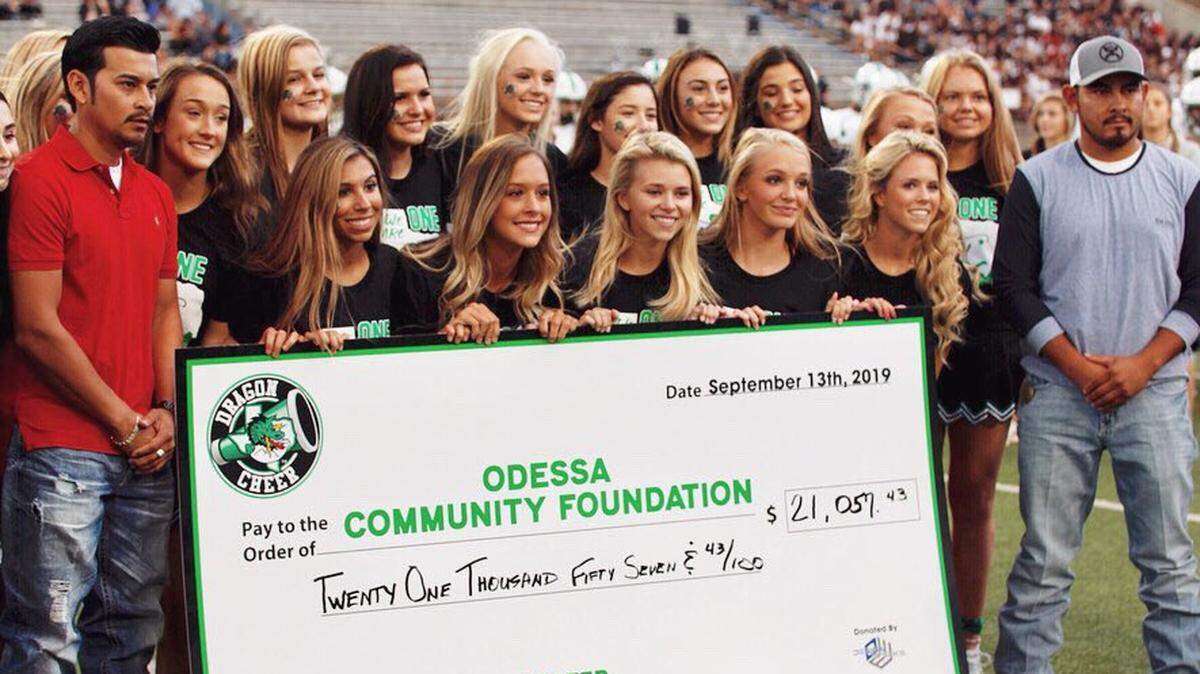 Carroll cheer team presents a check to the Odessa families during a game against Permian Friday, Sept. 13, 2019.