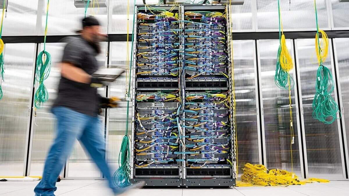 In this handout provided by Amazon, An Amazon Web Services technician passes on a AWS UltraServer in Austin, Texas on Oct. 2, 2025.