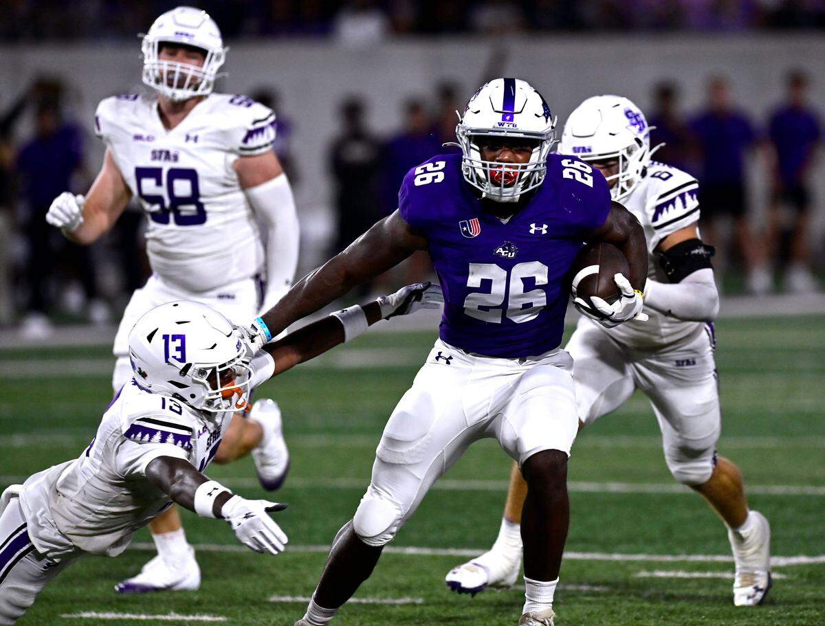 ACU running back Jordon Vaughn stiff-arms SFA cornerback Aaron Sears as he carries the ball downfield for an eventual touchdown Saturday Sept. 6, 2025. Abilene Christian University defeated Stephen F. Austin University at home, 28-20.