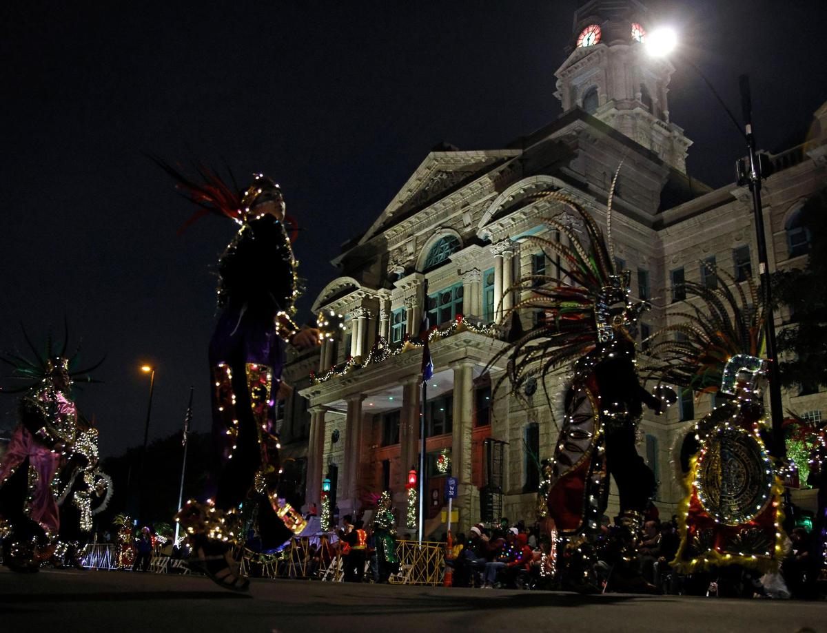 Dancers from Ballet Folklorico Quetzal pass the Tarrant County Courthouse during the 2023 GM Financial Parade of Lights.