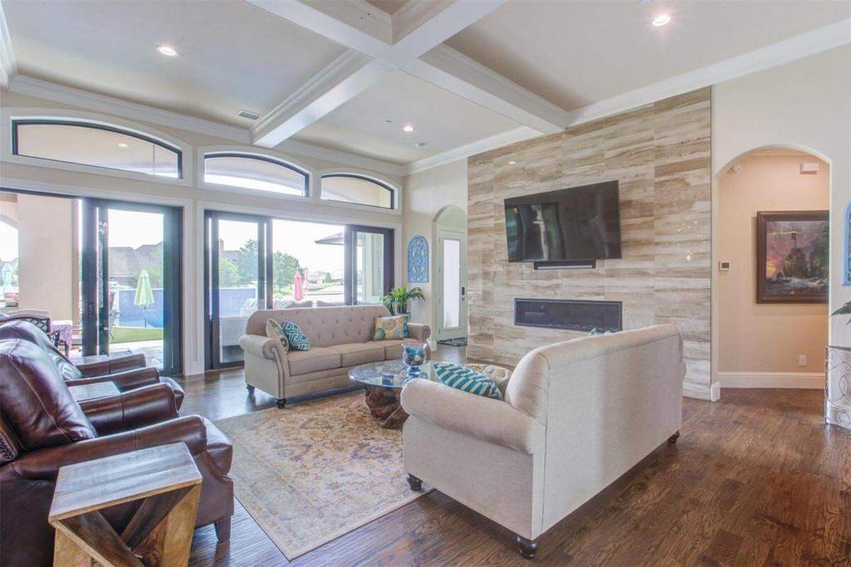 A home built to entertain that has an open living room to kitchen concept and inviting double doors to the outside patio.