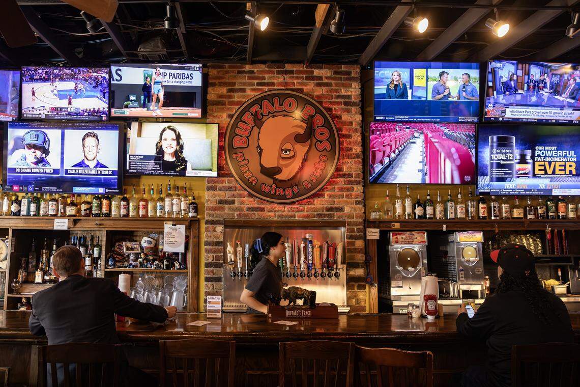 Server Mycayla Orona walks through the bar during the post lunch rush at Buffalo Bros restaurant near TCU in Fort Worth on Wednesday, Dec. 3, 2025.