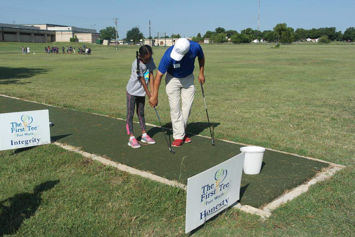 Briscoe Learning Center Site Coordinator Jason Rocha works with The First Tee of Fort Worth participants on their driving.