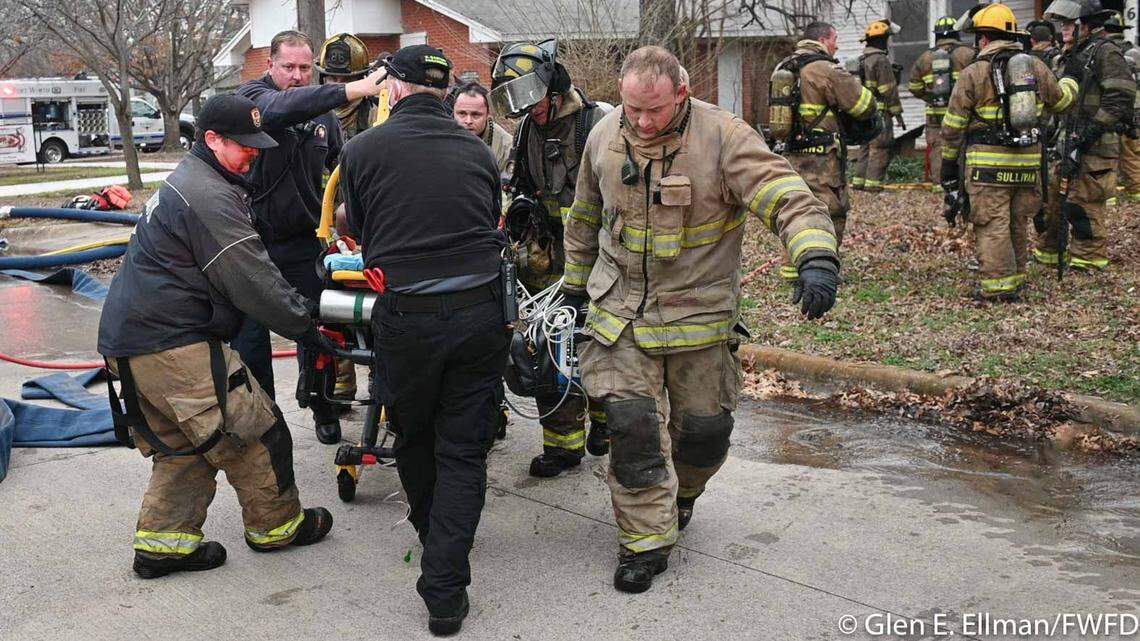 Firefighters move a man on a stretcher who was critically injured in a house fire in east Fort Worth on Friday afternoon. CareFlite took him to Parkland Memorial Hospital in Dallas.