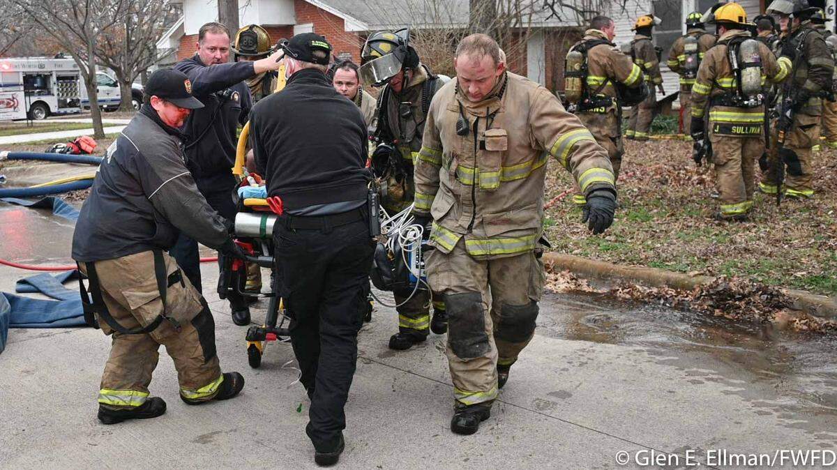 Firefighters move a man on a stretcher who was critically injured in a house fire in east Fort Worth on Friday afternoon. CareFlite took him to Parkland Memorial Hospital in Dallas.