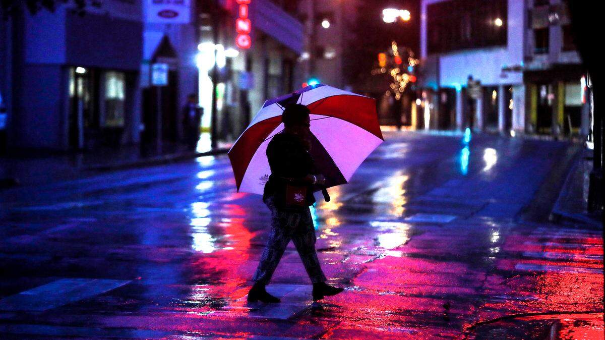 Rain continues to fall as a pedestrian makes her way to work in downtown Fort Worth in an archive photo.