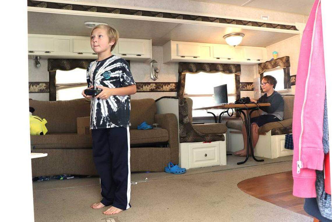 Ashton Eichberger (left) and his older brother, Aiden Eichberger (right), play video games together in the RV that became their temporary home after Harvey flooded their house in Friendswood, Texas.