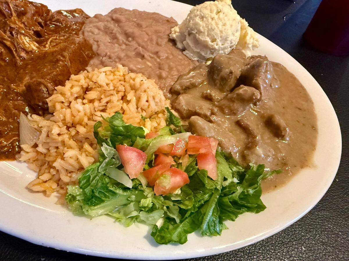 The “Miss Piggy” plate at Tia’s on the Bluff has both carne guisada, right, and chicken in mole sauce, seen Dec. 14, 2024.