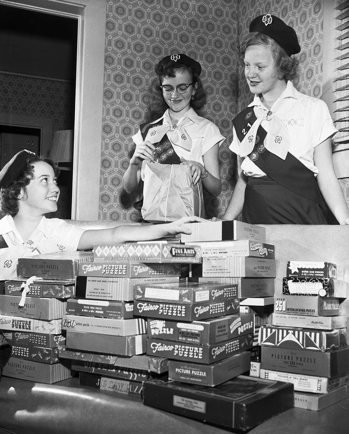 Dec. 1, 1953: Girl Scouts of Troop 21, left to right, Sharon Lowe, Carolyn Dodd and Lawrencene Winters gather their collection of jigsaw puzzles which Scouts throughout the city are collecting for patients of the U.S. Public Health Service Hospital. Approximately 500 puzzles had been collected by the city’s Girl Scouts.