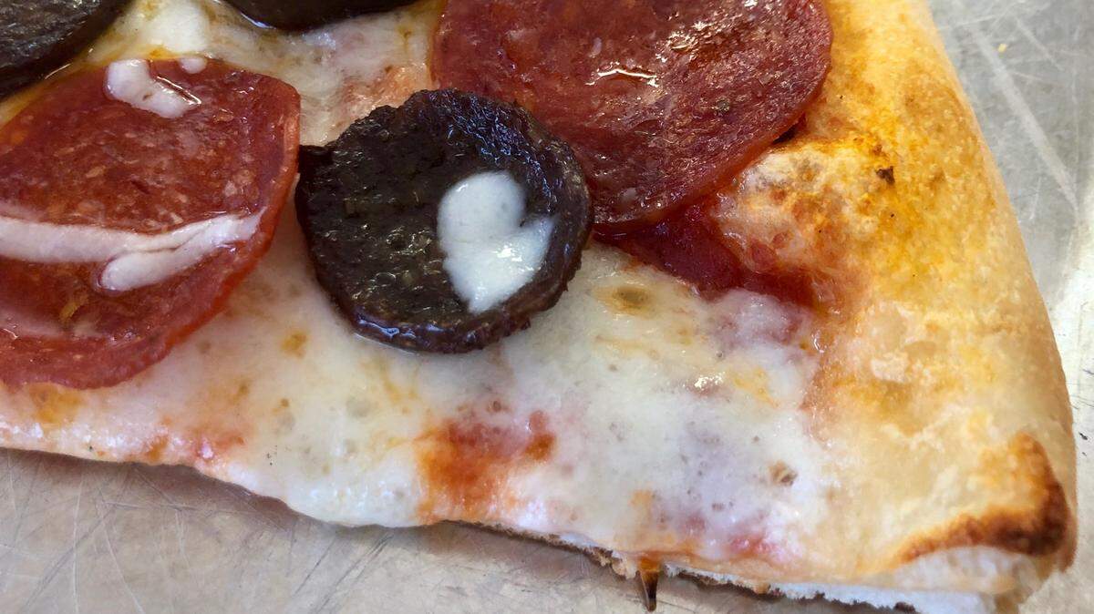 Pizza by the slice with pepperoni and Italian sausage at Italiano’s in River Oaks.