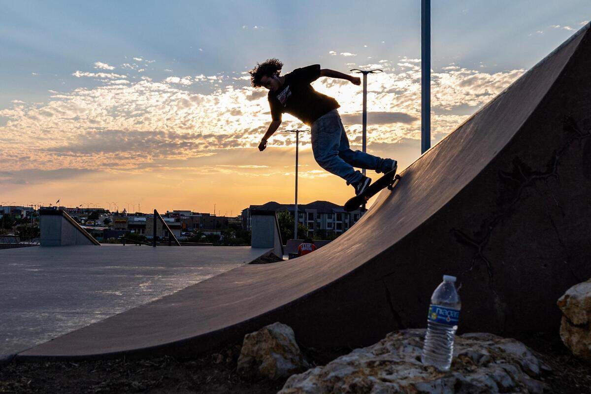 Kaleb Worthington skates up a slope at sunset at Chisholm Trail Skate Park in Fort Worth on Tuesday, Aug. 29, 2023.