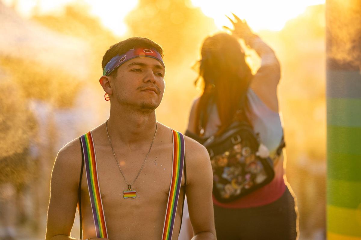 Christian Pitts takes a break from the sun under the cooling mist area at the Arlington Pride event at Levitt Pavilion in Arlington on Saturday, June 8, 2024.